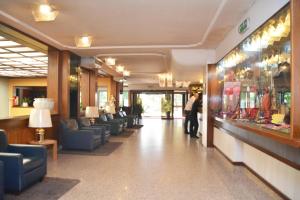 eine Eingangshalle eines Krankenhauses mit Sofas und einer stehenden Person in der Unterkunft Hotel Delta Florence in Calenzano + 106 Fotos