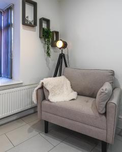 a living room with a chair and a lamp at Cranberry House Stylish 3BR, 7 Guests Contractor with Cinema Room Near JLR NEC and Airport in Sheldon +39 photos