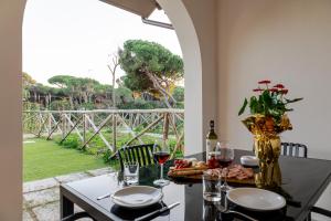 a table with a vase of flowers and wine glasses at Borgo Del Navigatore in Marina di Grosseto
