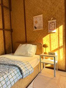 a bedroom with a bed and a table with a lamp at TEAK HOUSE In TOWN in Mae Hong Son