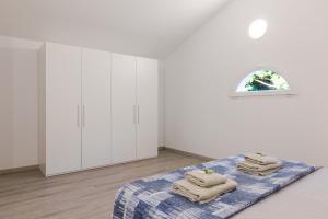 a white room with a bed with towels on it at Borgo Del Navigatore in Marina di Grosseto