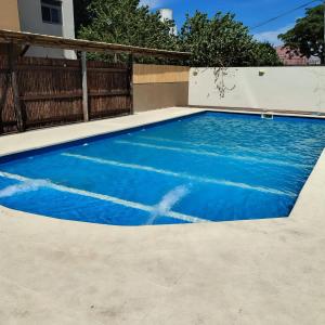 a swimming pool with blue water in a backyard at Los corales torre norte in Santa Teresita