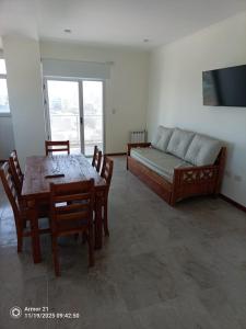 a living room with a couch and a table and chairs at Los corales torre norte in Santa Teresita