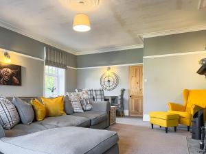 a living room with a couch and a yellow chair at Cracken Cottage - Uk48297 in Chinley