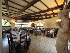 a statue in a restaurant with tables and chairs at Fruit Village Torre dell'Orso La Brunese 4stelle in Torre dell'Orso