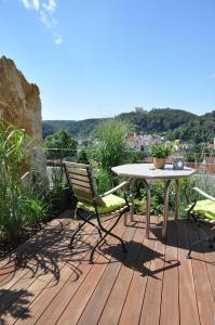 a table and a chair on a wooden deck at Ferienwohnung Burgenblick mit Blick auf Riedenburg in Riedenburg