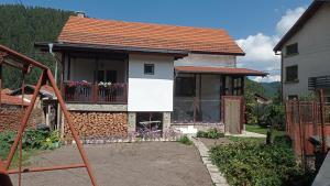 a small house with a balcony with flowers on it at Guest House Марковата Къща in Madzhare