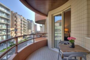 a balcony with a wooden table and chairs and a window at Mouzinho50 - Elegant Apartment in Póvoa de Varzim