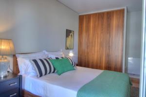 a bedroom with a white bed and a wooden cabinet at Mouzinho50 - Elegant Apartment in Póvoa de Varzim