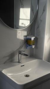 a white bathroom sink with a mirror and a mirror at Southlux in Tossor +84 photos