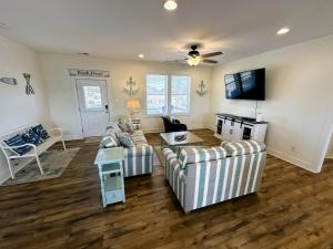 a living room with two couches and a flat screen tv at KD1730 - Cole's Cabana in Kill Devil Hills