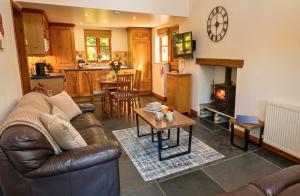 a living room with a leather couch and a fireplace at CROYDE THATCHERS HIDEAWAY 2 Bedrooms in Croyde