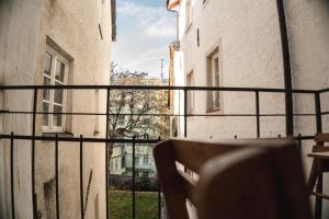 a balcony with a chair and a view of a street at Sir Thomas Bed Central in Bolzano