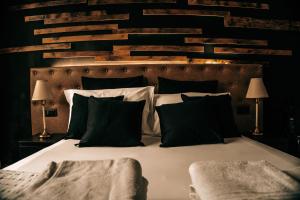 a bedroom with a bed with black and white pillows at Sir Thomas Bed Central in Bolzano +3 photos