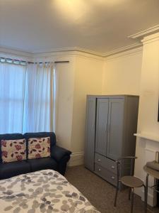 a bedroom with a blue couch and a cabinet at Palace in Crystal Palace