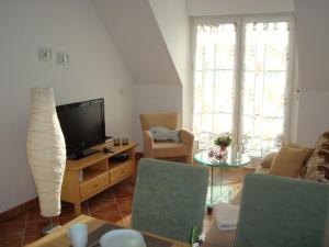 a living room with a couch and a tv at Küstenliebe in Kirchdorf