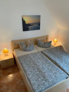 a bedroom with two beds and two lamps on tables at Küstenliebe in Kirchdorf