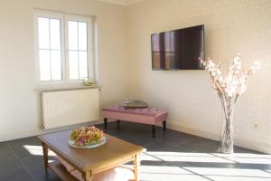 a living room with a table and a vase of flowers at 'Op de Borgt' met Finse Grill Kota in Wellen