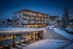 a large building in the snow at night at Hotel Langhof in Natz-Schabs