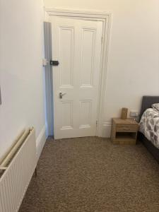 a bedroom with a white door and a bed at Palace in Crystal Palace