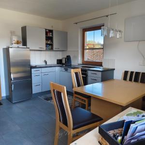 a kitchen with a wooden table and a refrigerator at Ferienwohnung Pusteblume4 in Oberau