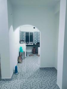 a hallway with white walls and a floor with a geometric pattern at Laxmi Narasimha homestay in mayapur