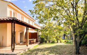 a patio of a house with a table and a tree at Maison 1 in Montauroux