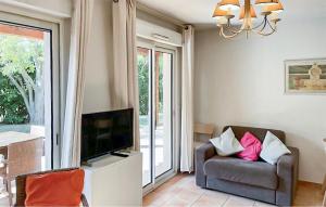 a living room with a chair and a television at Maison 1 in Montauroux