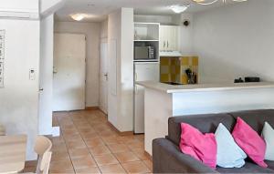 a living room with a couch and a kitchen at Maison 1 in Montauroux