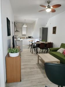 a living room with a green couch and a kitchen at Casa Rural "Baru" in Alpandeire