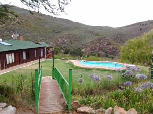 a house with a deck and a swimming pool at Eagle Falls Country Lodge & Adventures in Buffelsdrif