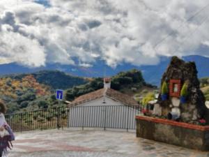 a building with a gate and a mountain in the background at Casa Rural "Baru" in Alpandeire