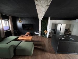 a living room with a green couch and a table at La Black Casa in Zafra +19 photos