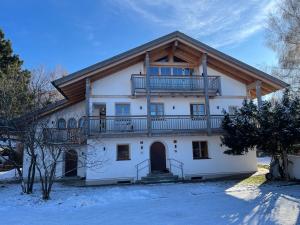 a large white house with a balcony on top at Alpen Apartment "Ruhe & Erholung" in Oberammergau