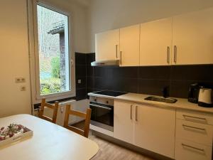 a kitchen with white cabinets and a table and a window at Gemütliche Unterkunft Sankt Blasien in St. Blasien