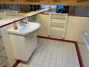 a white bathroom with a sink and a mirror at Alpen Apartment "Ruhe & Erholung" in Oberammergau