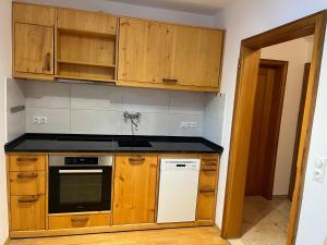 a kitchen with wooden cabinets and a stove top oven at Alpen Apartment "Ruhe & Erholung" in Oberammergau