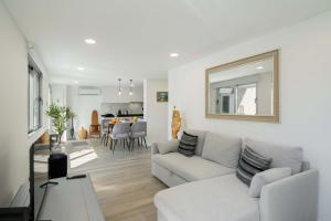 a living room with a couch and a mirror at OurMadeira - Terrace Sea Apartments in Ribeira Brava