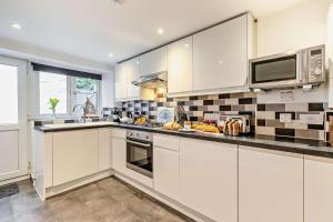 a kitchen with white cabinets and a microwave at 2 Bed in Wadebridge oc-r27444 in Little Petherick