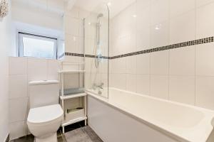 a white bathroom with a toilet and a bath tub at 2 Bed in Wadebridge oc-r27444 in Little Petherick +21 photos