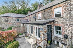 a brick house with a bench in front of it at 2 Bed in Wadebridge oc-r27444 in Little Petherick