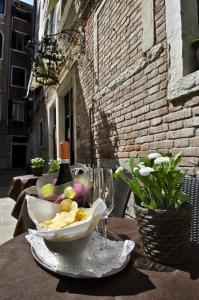 a table with a bottle of wine and a bowl of chips and a glass at Locanda Casa Querini in Venice