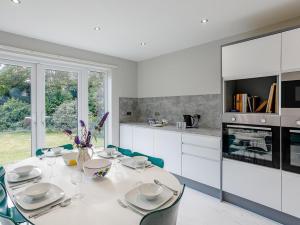 a white kitchen with a white table and chairs at 4 Bed in Mablethorpe oc-77958 in Sutton on Sea