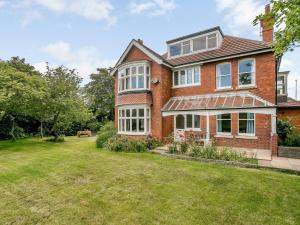 an exterior view of a brick house with a yard at 4 Bed in Mablethorpe oc-77958 in Sutton on Sea