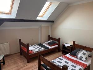 a attic room with two beds and two windows at Agroturystyka Maya in Gorzyca +6 photos