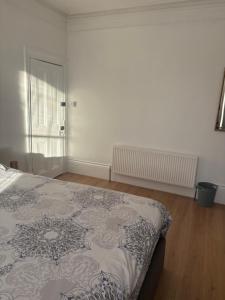 an empty bedroom with a bed and a window at Crystal in Crystal Palace