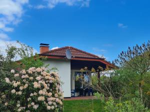 a white house with a red roof and some flowers at Haus Austernfischer in Schweiburg