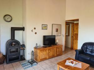 a living room with a television and a stove at Haus Austernfischer in Schweiburg