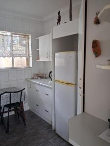 a kitchen with a white refrigerator and a table at Stop-a-While in Krugersdorp