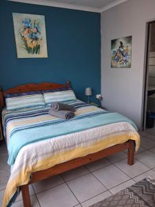 a bedroom with a large bed with blue walls at Stop-a-While in Krugersdorp